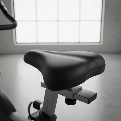A close-up shot of a padded gel exercise bike seat cover properly installed on a black exercise bike saddle, highlighting its cushioning effect.